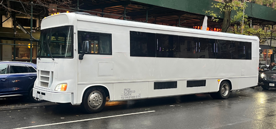 White 37-passenger limo bus.